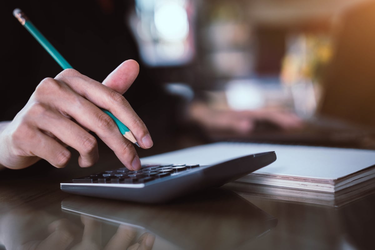 Businesswoman hand pressing on calculator for calculating cost estimating.